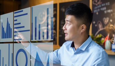 A man giving a presentation with charts and graphs 