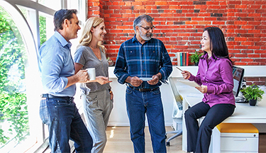Four coworkers talking in the office